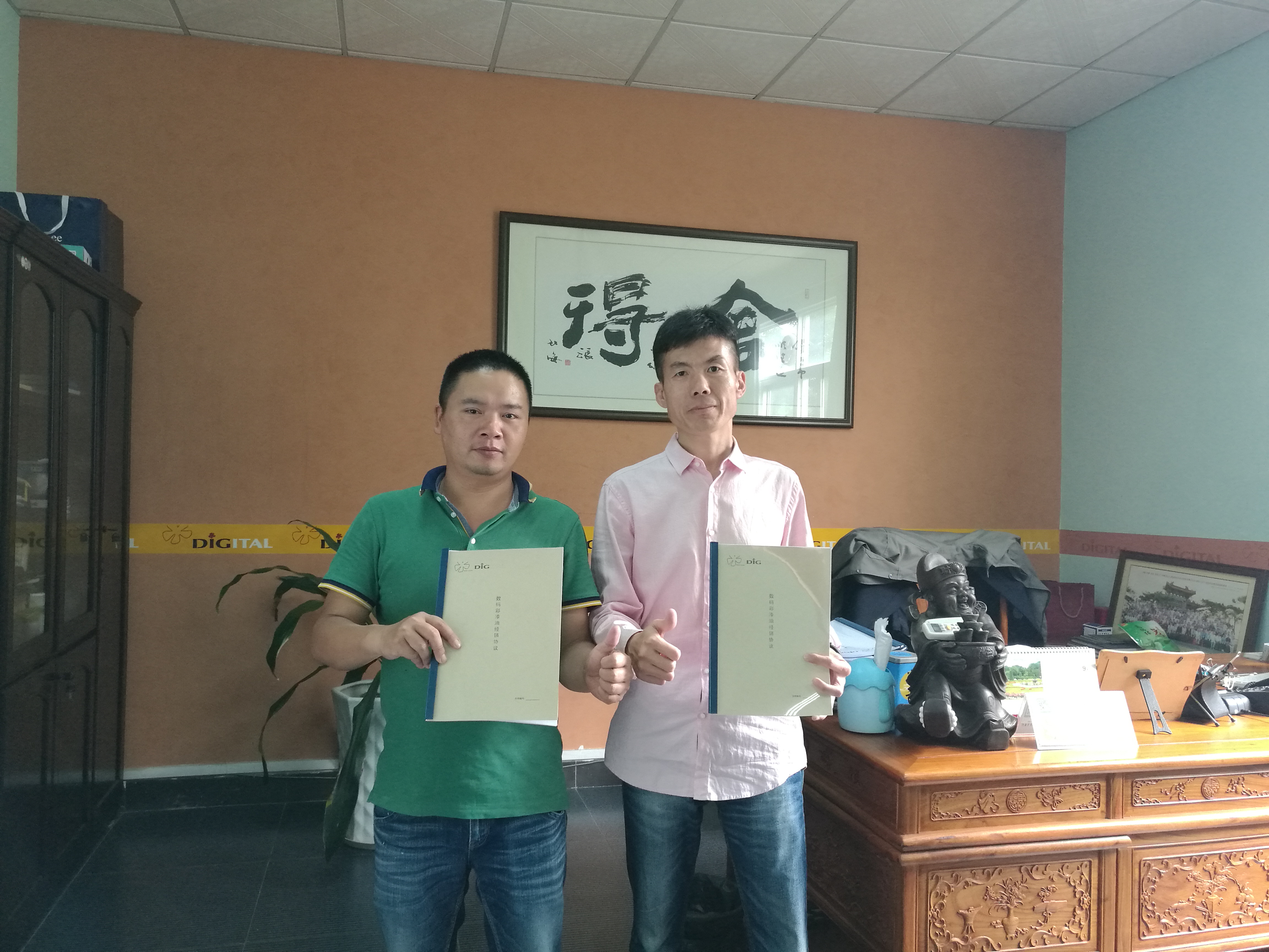 油漆涂料經(jīng)銷商何總（左）與數(shù)碼彩漆銷售總監(jiān)蔣方海合影